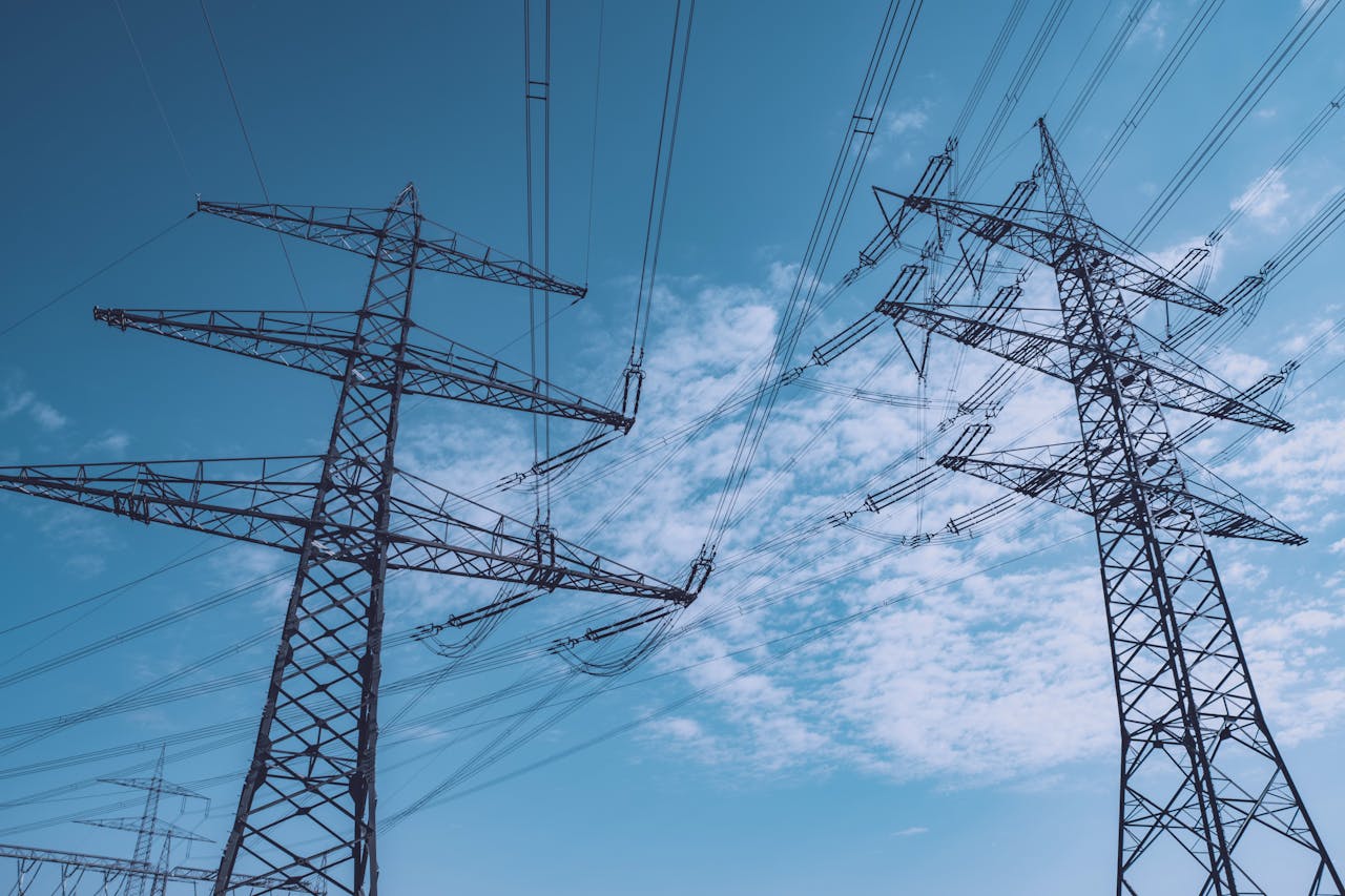 The Art of Drawing Readers In: Your attractive post title goes here High voltage transmission towers stretch across a clear blue sky, symbolizing energy and industry.
